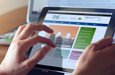 hands using tablet showing the NIC website