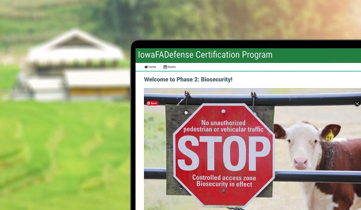 laptop displaying a screen from the Iowa FADefense course showing a cow behind a gate affixed with a BiosecuritySTOP sign