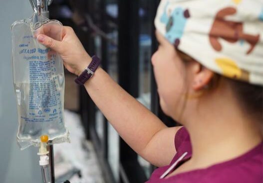 vet tech adjusting saline bag